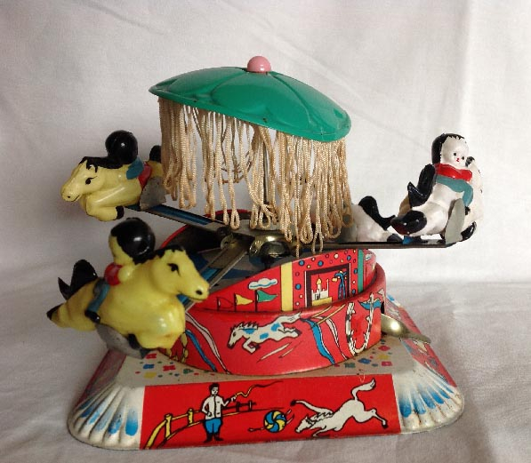 circa 1950's Chinese tin plate and celluloid clock work wind up carousel toy